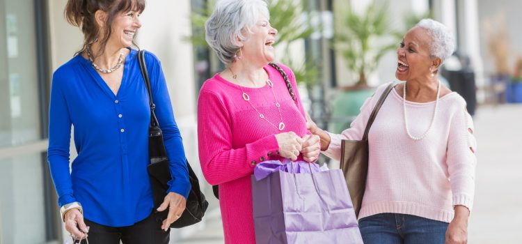 Group of three women laughing outside.