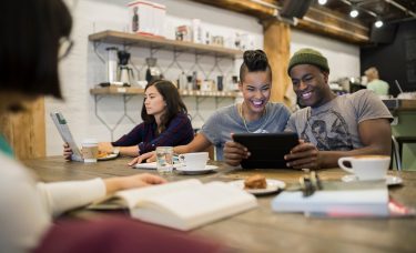 Young couple sitting at a coffee house, talking about how to financially prepare for a job transition