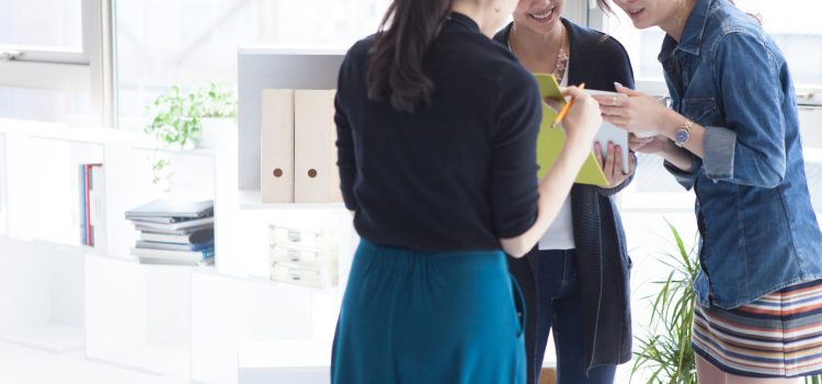 Three coworkers reviewing meeting notes in the office