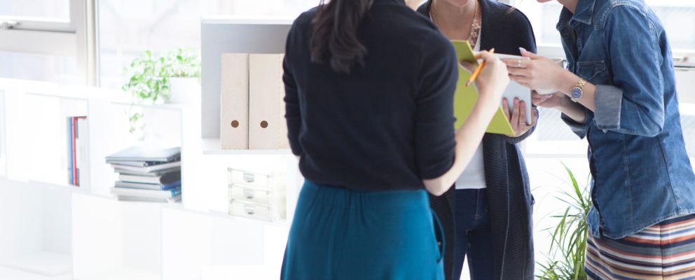 Three coworkers reviewing meeting notes in the office