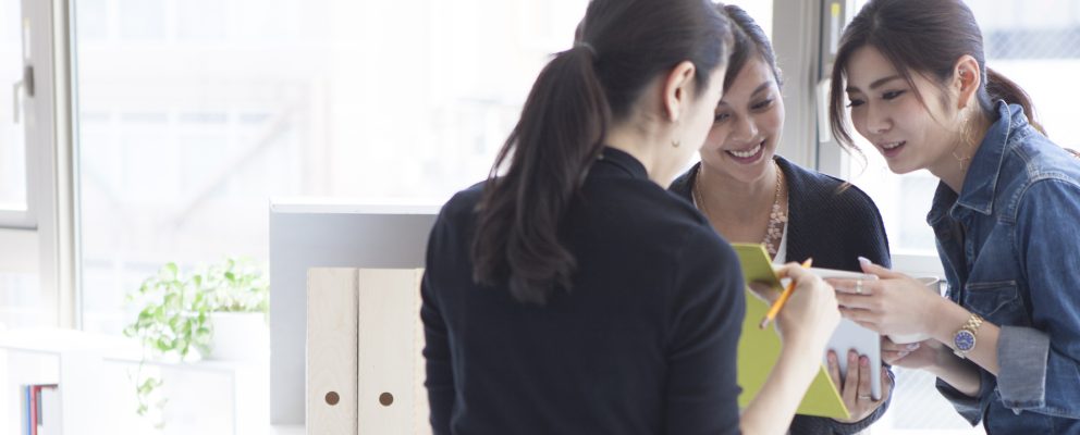 Three coworkers reviewing meeting notes in the office