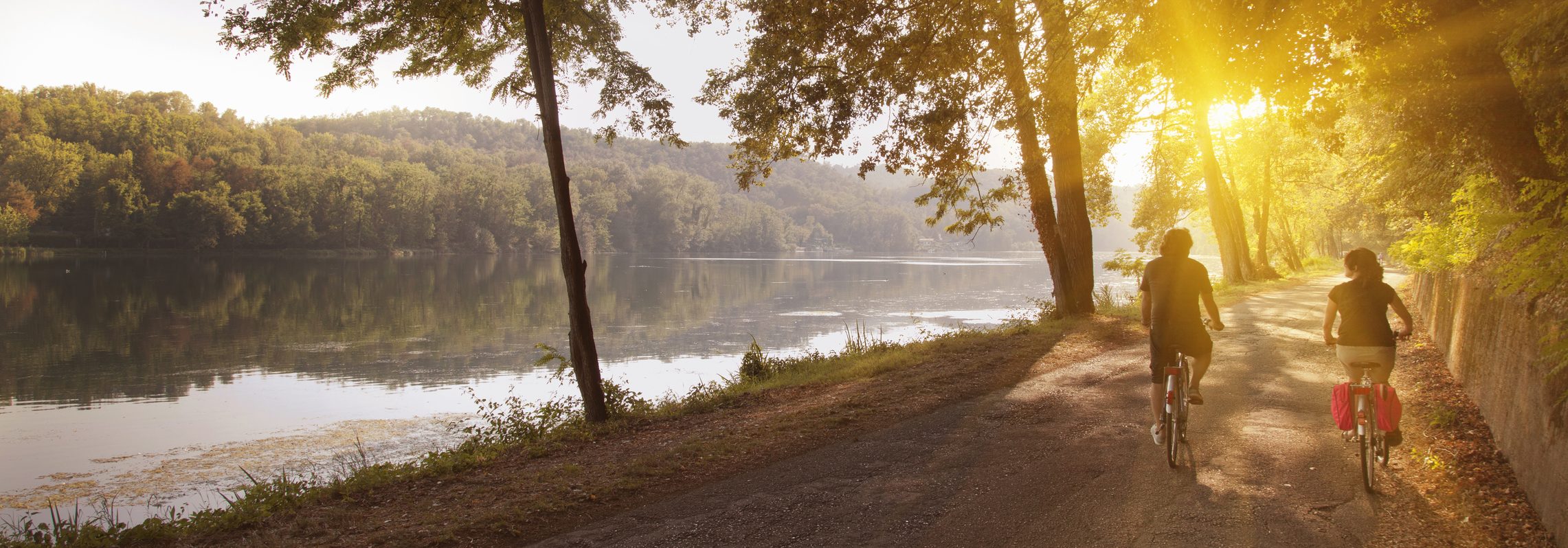 Couple riding bikes along the water.