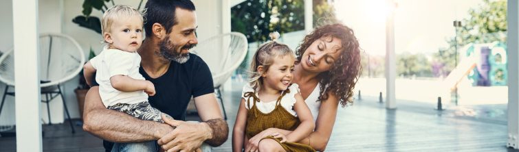 Young family sitting out on their front porch
