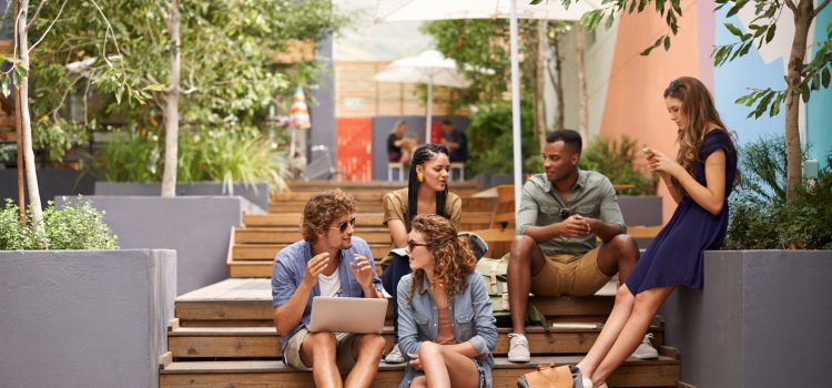5 students sit on stairs and converse