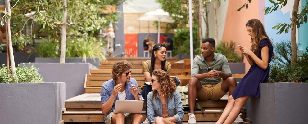 5 students sit on stairs and converse