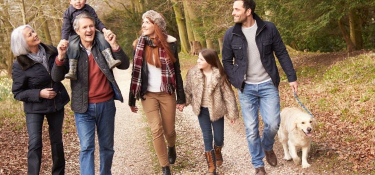 Grandparents walk outside with their grandson and his parents.