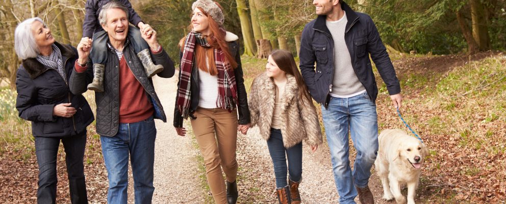 Grandparents walk outside with their grandson and his parents.