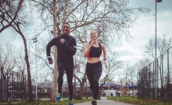 A man and a woman jog outside.