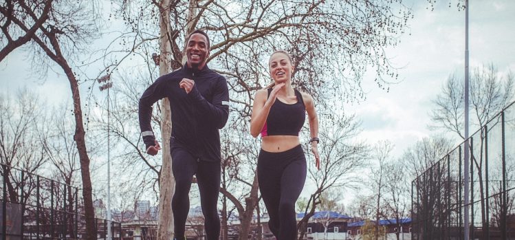 A man and a woman jog outside.