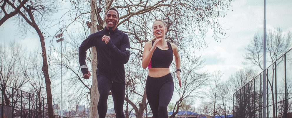A man and a woman jog outside.