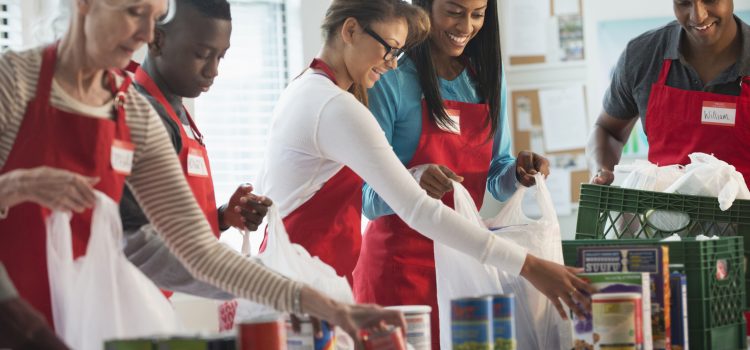 A group of young people with aprons work together.