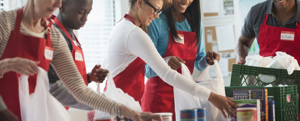 A group of young people with aprons work together.