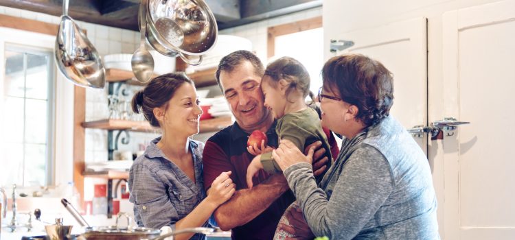 A family hugging in the kitchen.