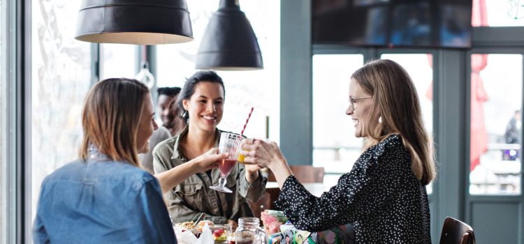 Three women toasting with various juice drinks.
