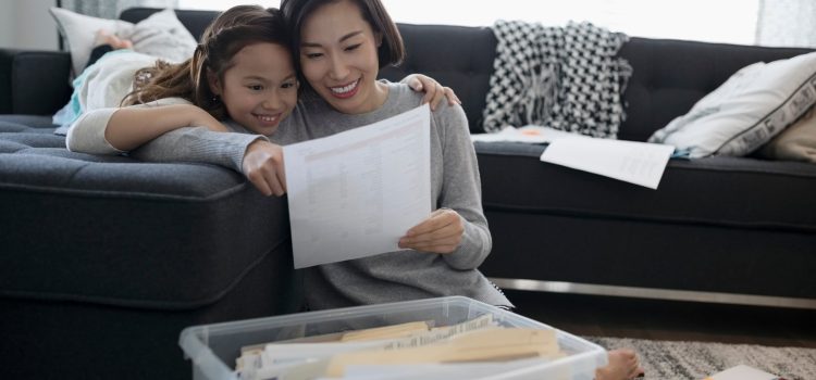 A mother and her daughter sit on a couch.