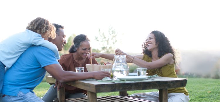 Grandparents share a meal with their daughter and grandchild.