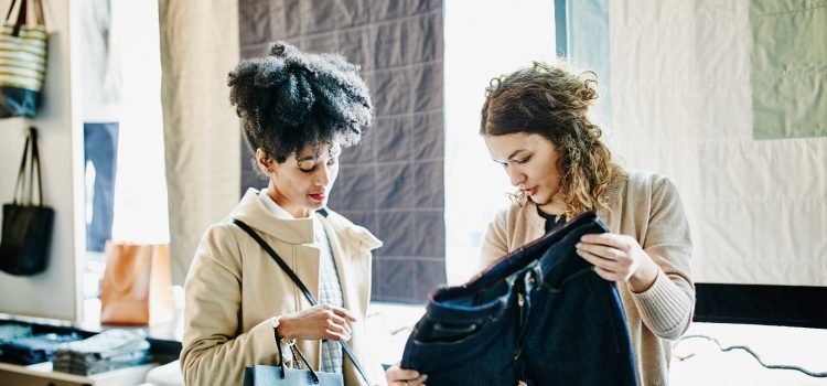 Two women look at a pair of pants.