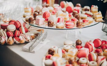 A selection of pink and white macaroons, canolis and other pastries.