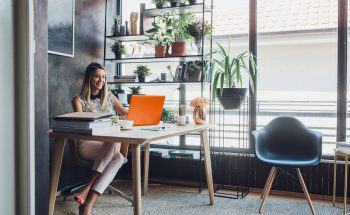 Woman sitting at a desk working on a laptop.