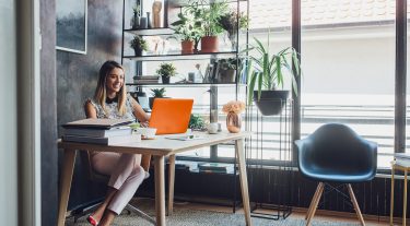 Woman sitting at a desk working on a laptop.