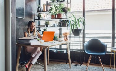 Woman sitting at a desk working on a laptop.