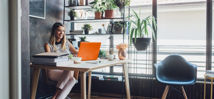Woman sitting at a desk working on a laptop.