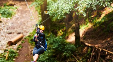 A woman rides a zip line.