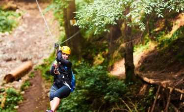 A woman rides a zip line.