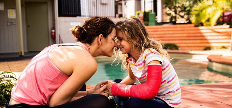Mom and daughter smiling with their foreheads pressed together.