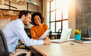 Man and woman at office reviewing paperwork together.