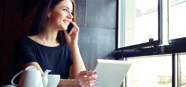Woman looks out the window while talking on the phone.