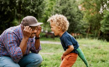Father and son playing together outside.