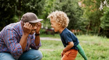 Father and son playing together outside.