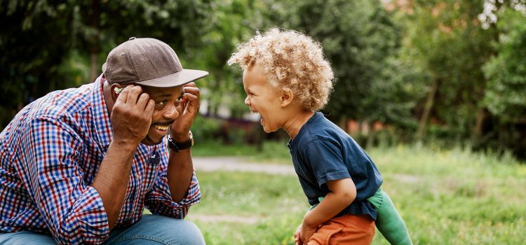 Father and son playing together outside.
