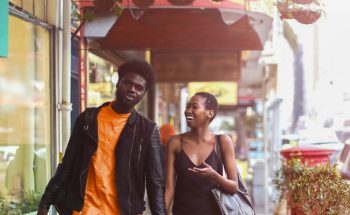 Couple laughing and walking down the street.