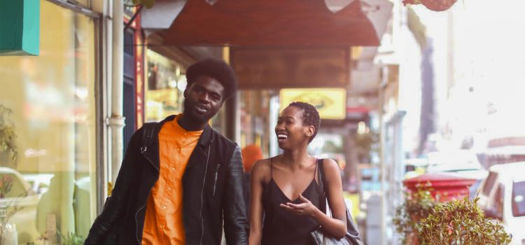 Couple laughing and walking down the street.