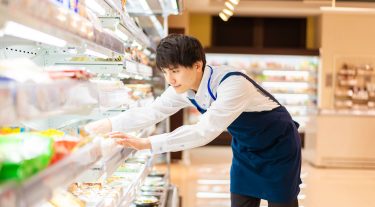 Man stocks shelves in a grocery store.