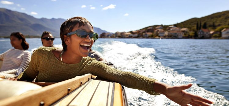 A woman holds her hand outstretched while riding on a boat