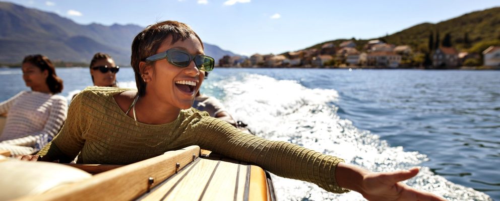 A woman holds her hand outstretched while riding on a boat