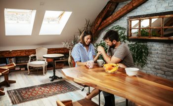 Man and woman holding hands and drinking coffee at a table.