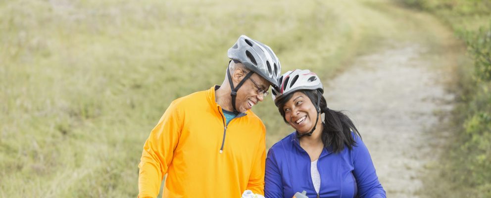 A couple riding bikes pauses to drink water on a trail.