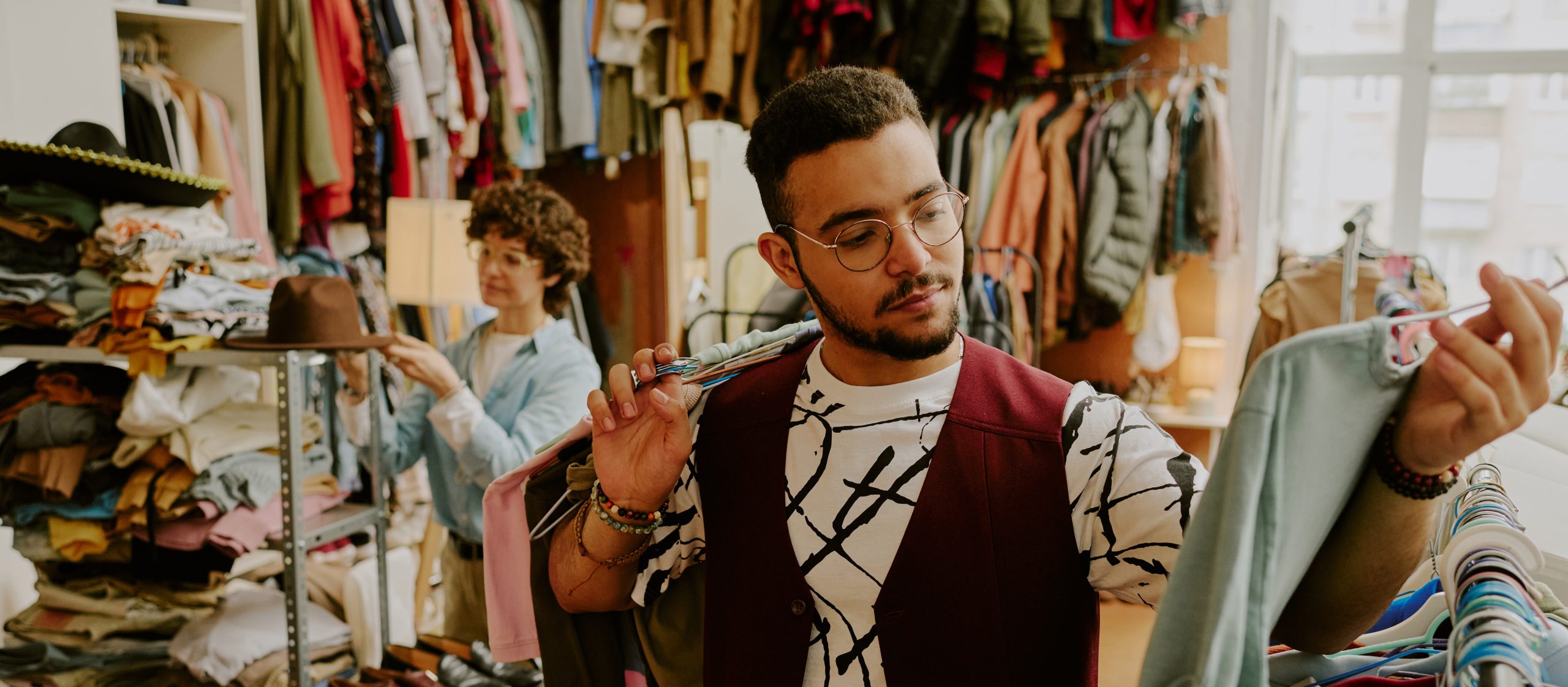 A young man browsing clothes
in a secondhand store.