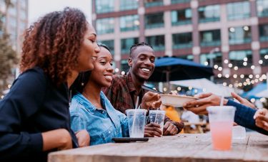 A group of people eating at an outdoor table.