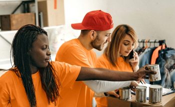 4 volunteers sort canned food into boxes