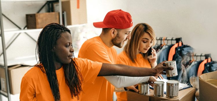4 volunteers sort canned food into boxes