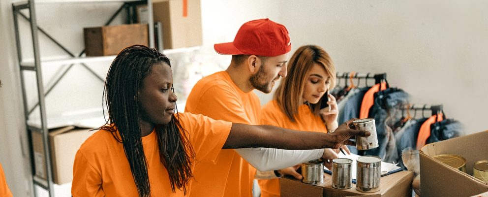 4 volunteers sort canned food into boxes