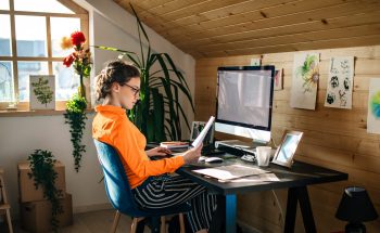A woman looks at a piece of paper while working at her desk