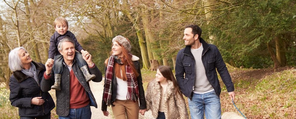 Grandparents walk outside with their grandson and his parents.