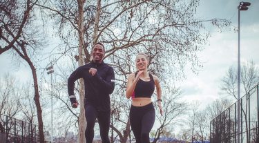 A man and a woman jog outside.