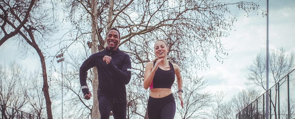 A man and a woman jog outside.
